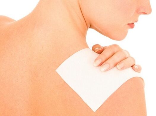 Une femme utilise un pansement pour soulager ses maux de dos